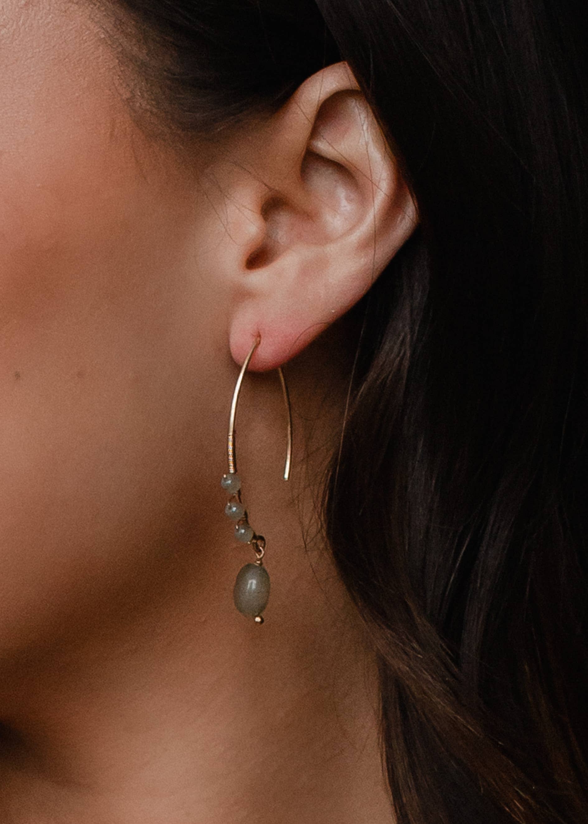Close-up of ear wearing 2-inch gold detailed beaded dangles earrings, lead and nickel free