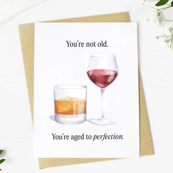 Big Mood Cards featuring hand-drawn wine and whiskey glasses with the text "You're not old. You're aged to perfection," printed on premium matte cardstock with a kraft envelope.