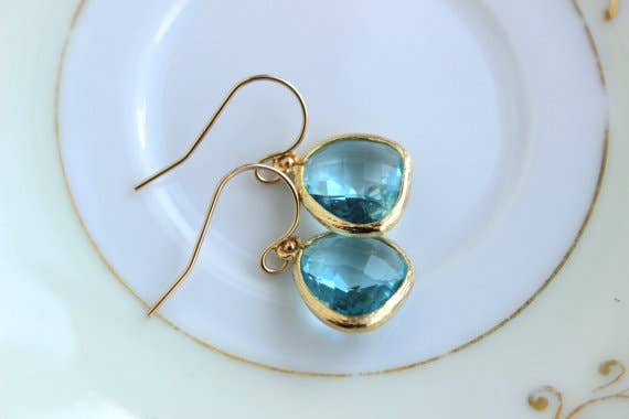 Gold plated aquamarine blue earrings with 14k gold filled earwires on a white plate