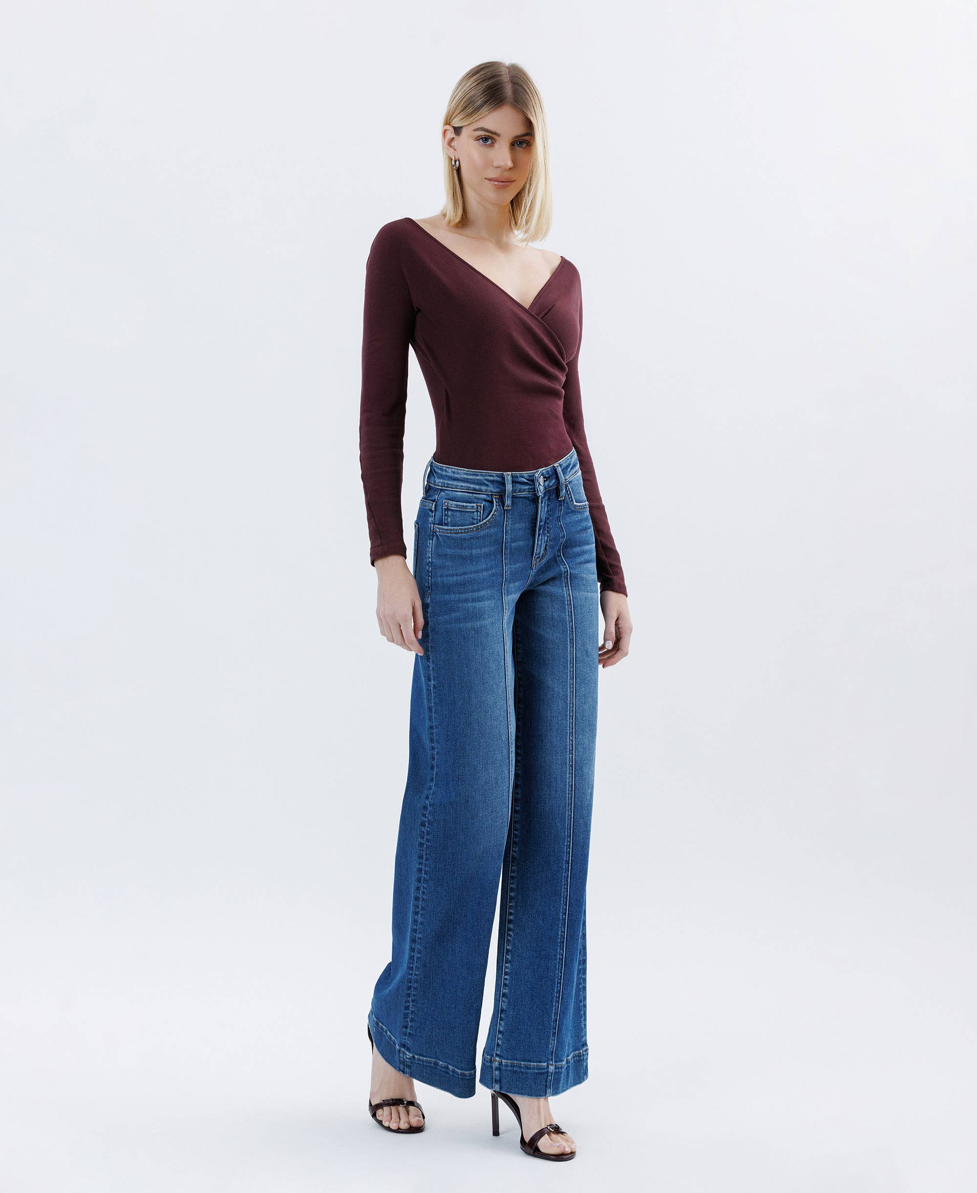 Woman wearing high rise Wide Leg Jeans trouser hem extreme wide leg jeans with a fitted maroon top and black heels