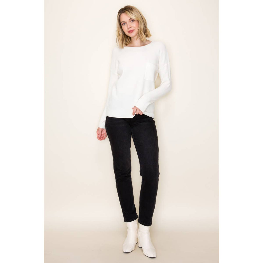 Woman wearing white waffle knit pullover sweater with chest pocket and long sleeves