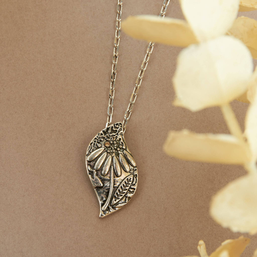 Silver pendant necklace with dahlia floral design and crystal accents on 18-inch chain