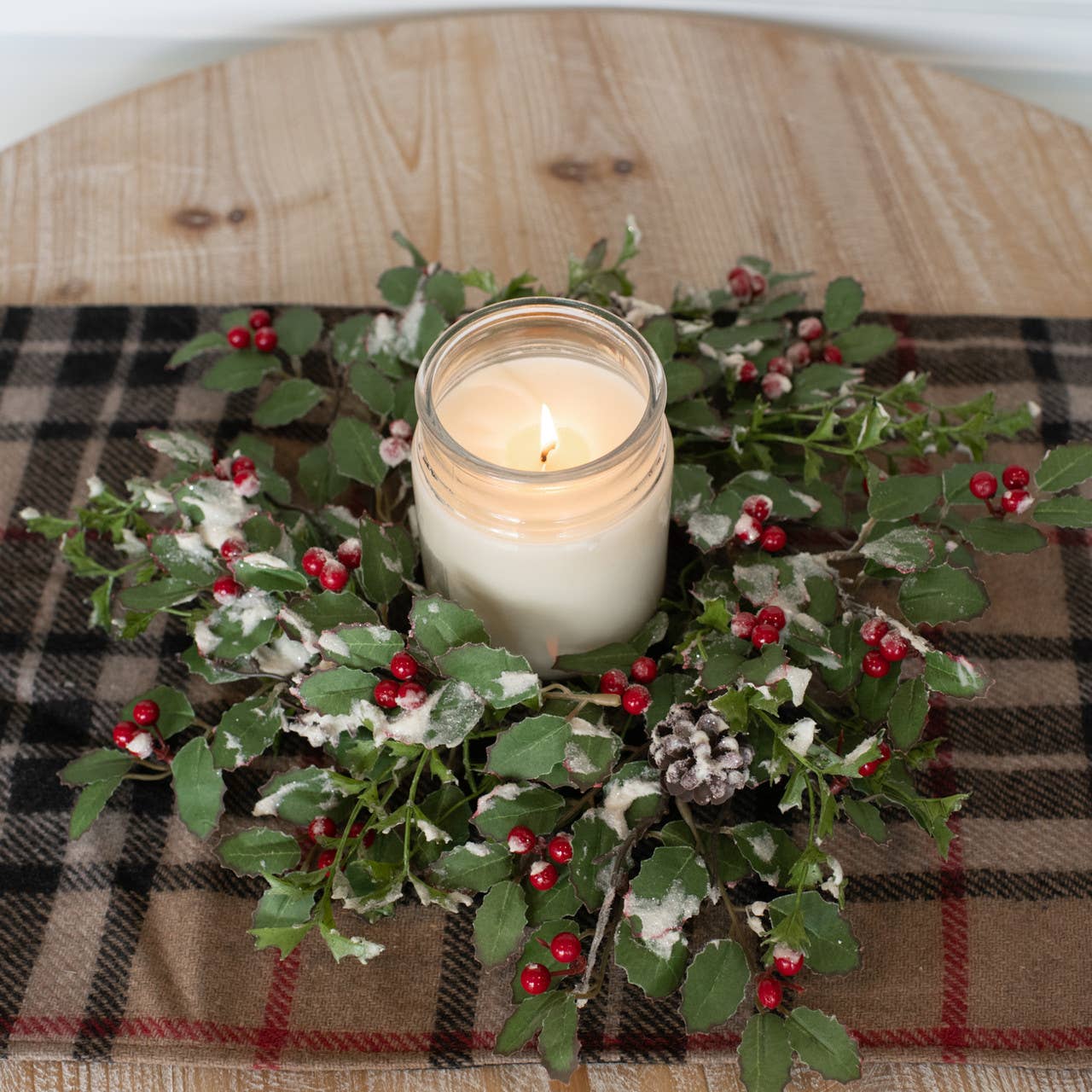 15" glittered holly, berry, and pinecone wreath with lit candle centerpiece on plaid cloth