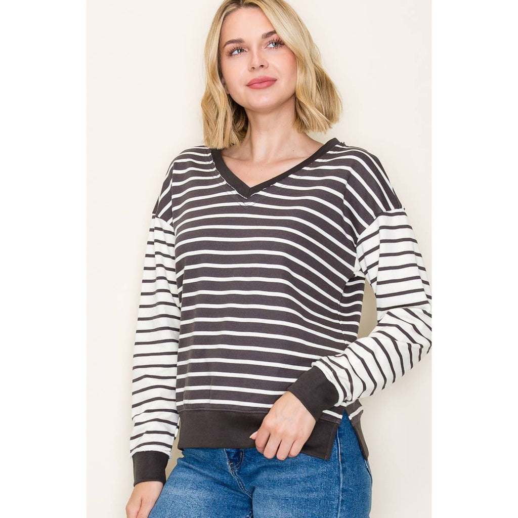 Woman wearing a French Terry long sleeve V-neck striped top with brown and white color-blocked stripes and ribbed cuffs.