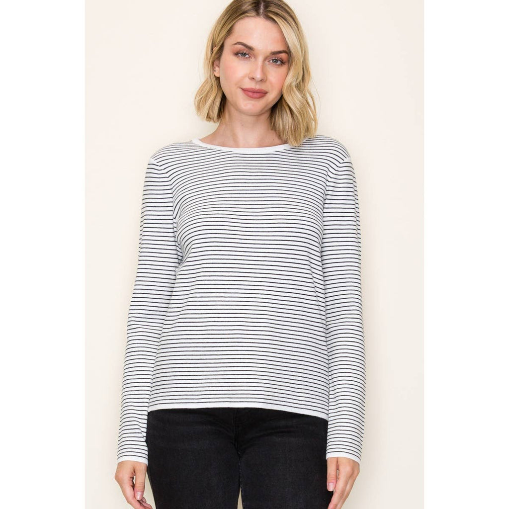 Woman wearing an ivory and taupe long sleeve pinstripe top with a crew neckline and relaxed fit.