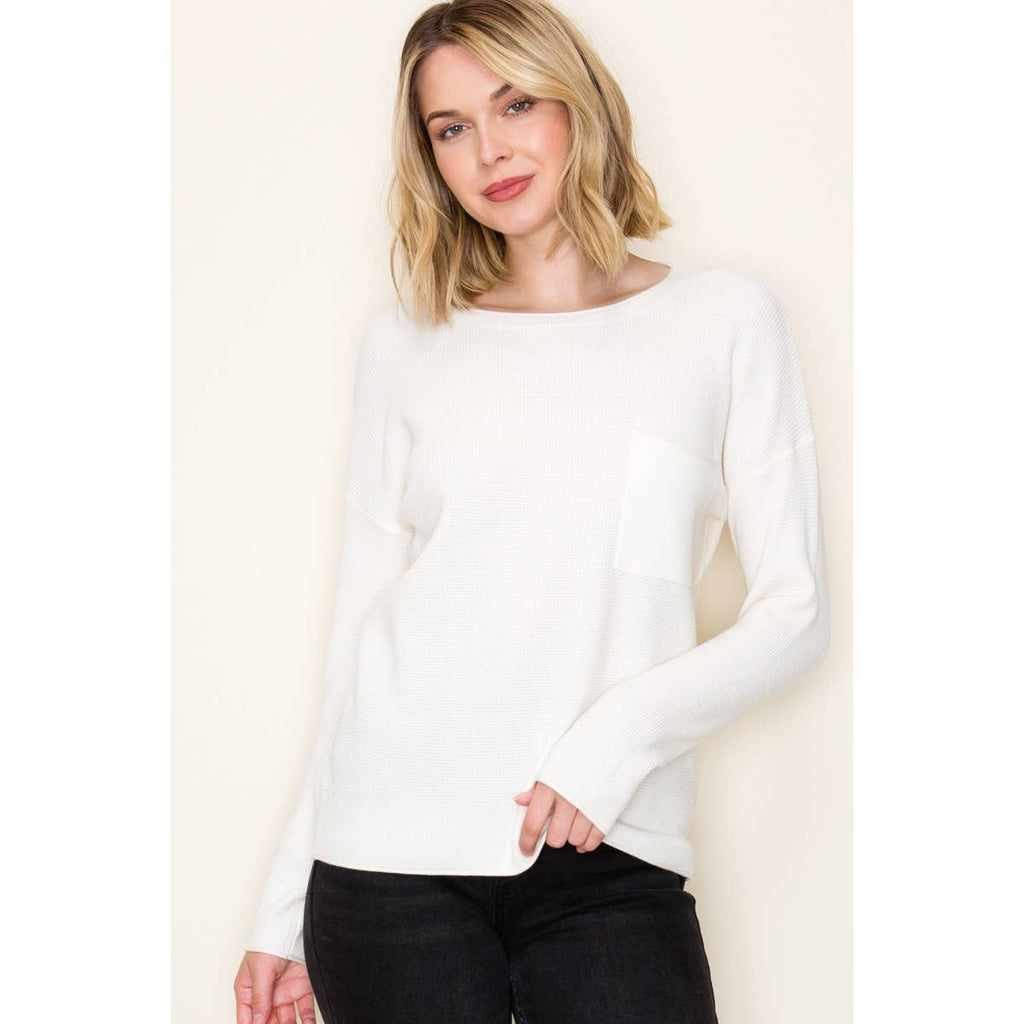Woman wearing white waffle knit pullover sweater with chest pocket and long sleeves