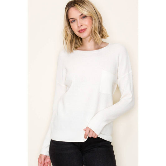 Woman wearing white waffle knit pullover sweater with chest pocket and long sleeves