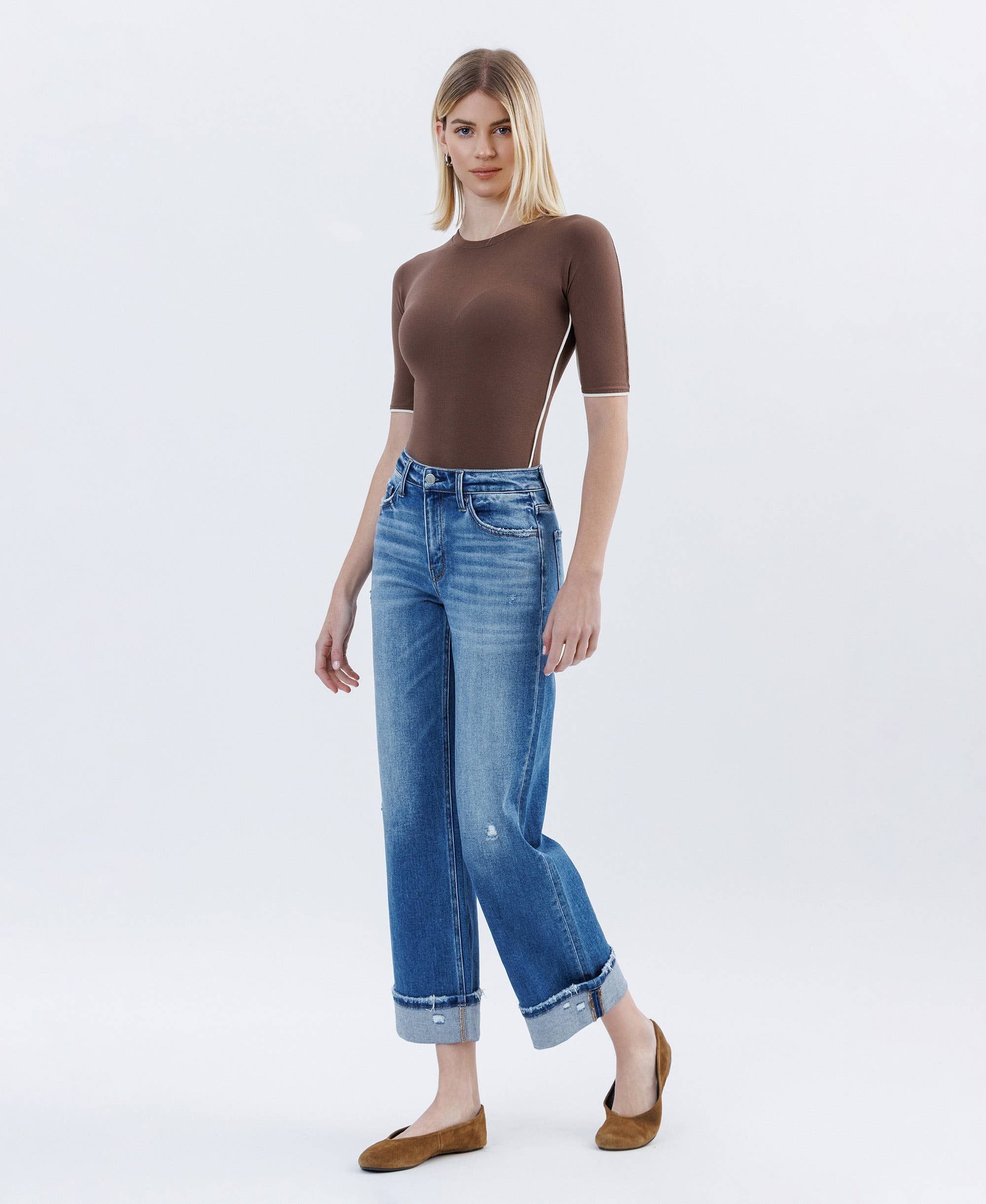 Woman wearing high rise cuffed slim wide leg jeans with slight distressing and cropped length