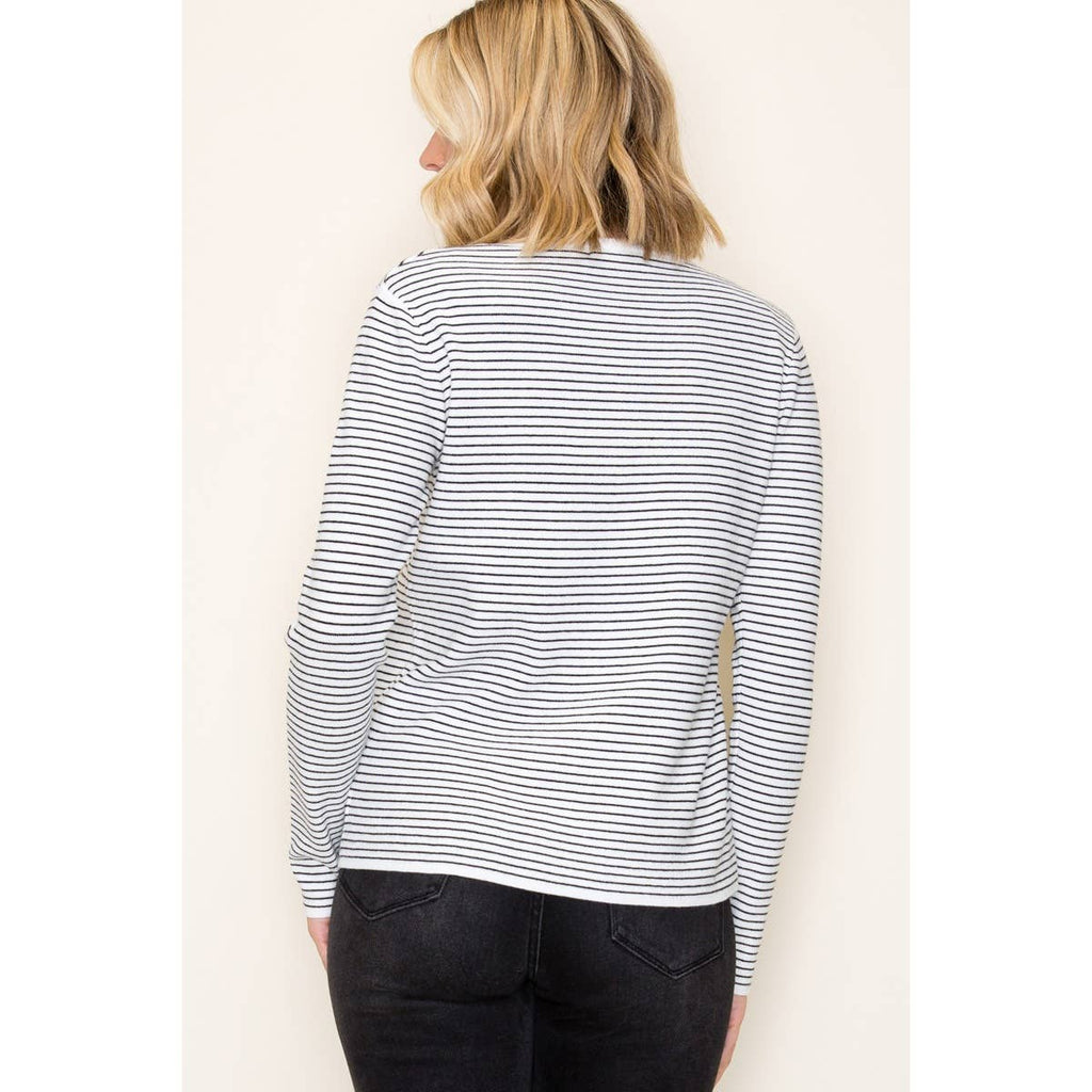 woman wearing ivory and taupe long sleeve pinstripe top with crew neckline and relaxed fit, back view